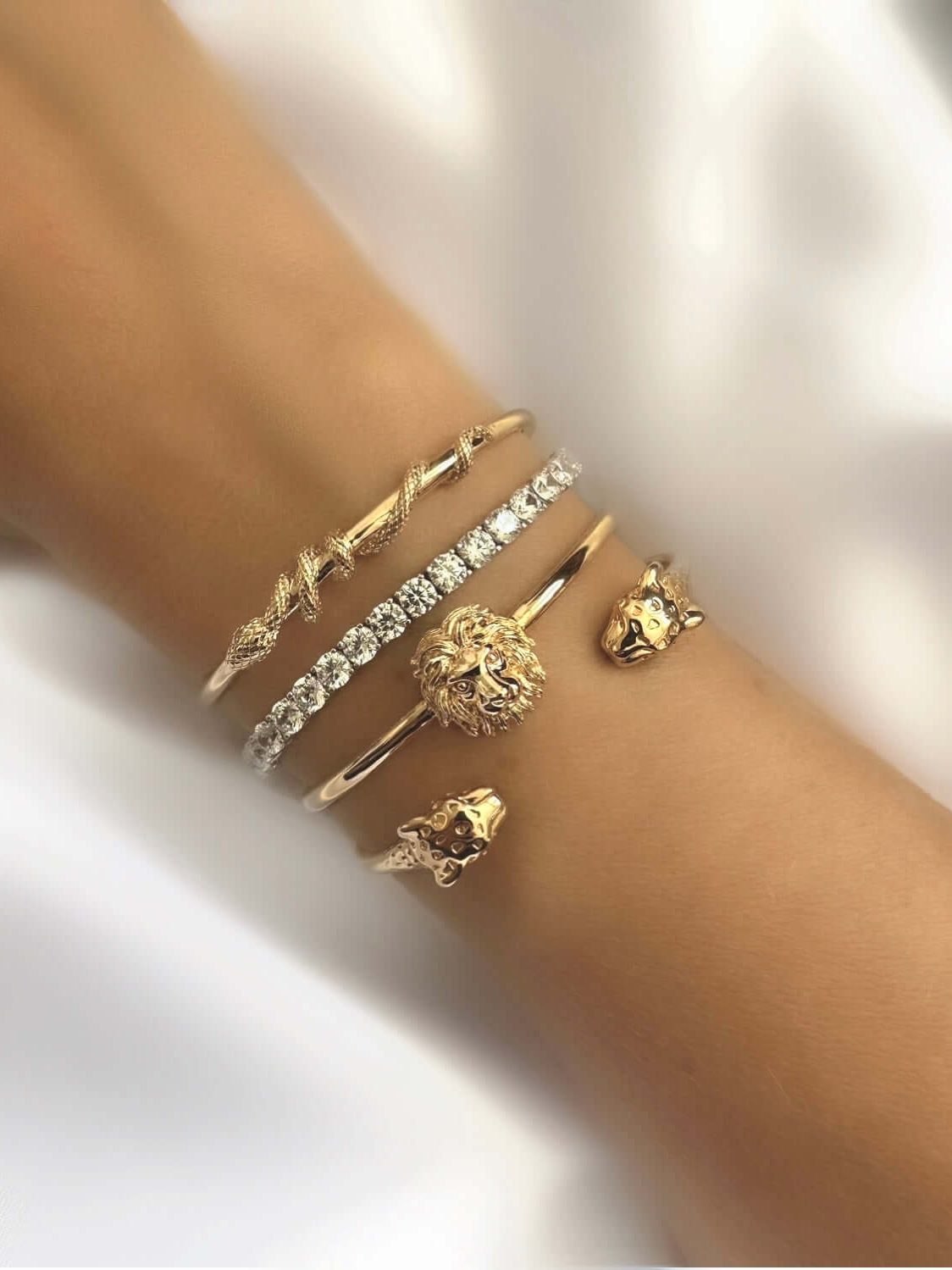 Pulsera Classic Riviere de Plata 925 con circonitas engarzadas, junto a pulseras estilo tenis y diseños de león en una muñeca.